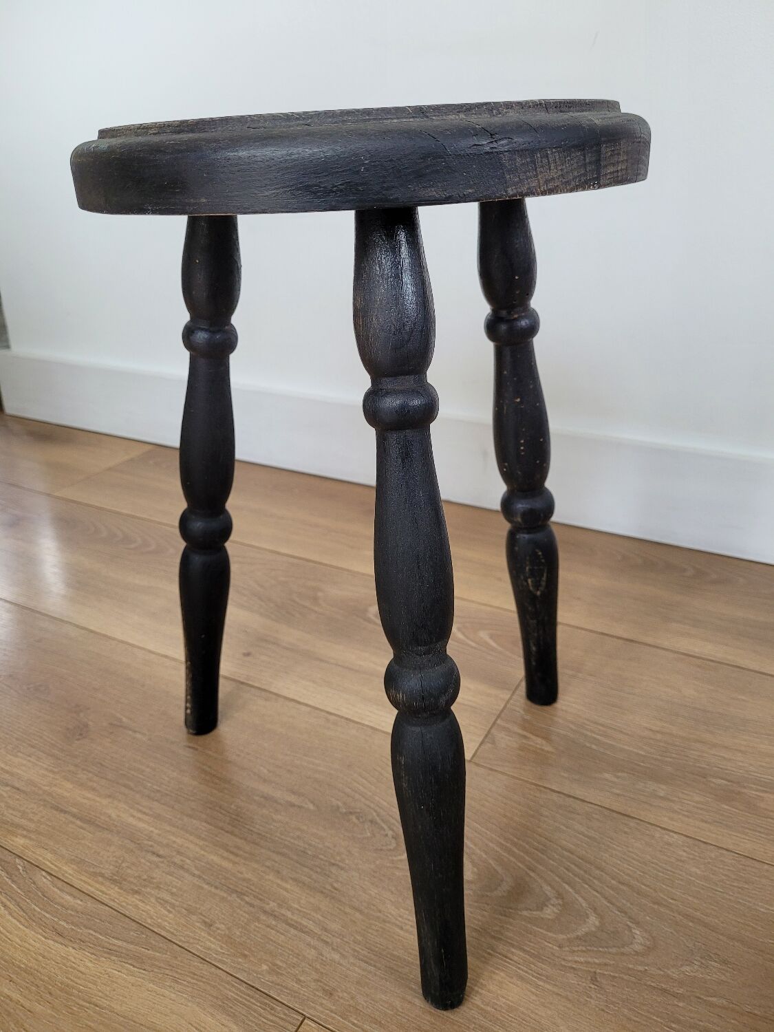 Black wooden tripod stool