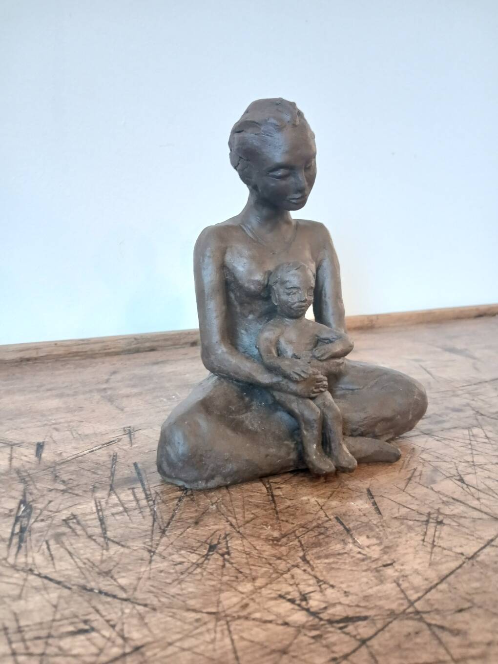 Terracotta statue of a woman with child, signed