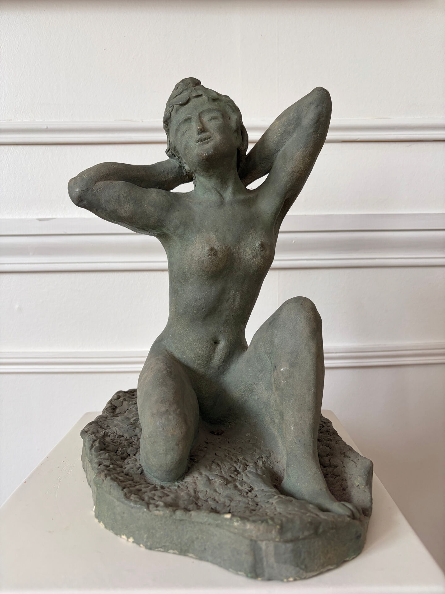 Sculpture of a naked woman titled "Youth" in terracotta.