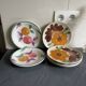 Italian ceramic plates with floral fruit designs.