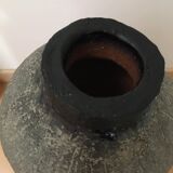 Terracotta vase with gradient of black faded to half on an earth-colored background