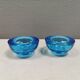 A set of iitalla candle holders in blue transparent glass.
