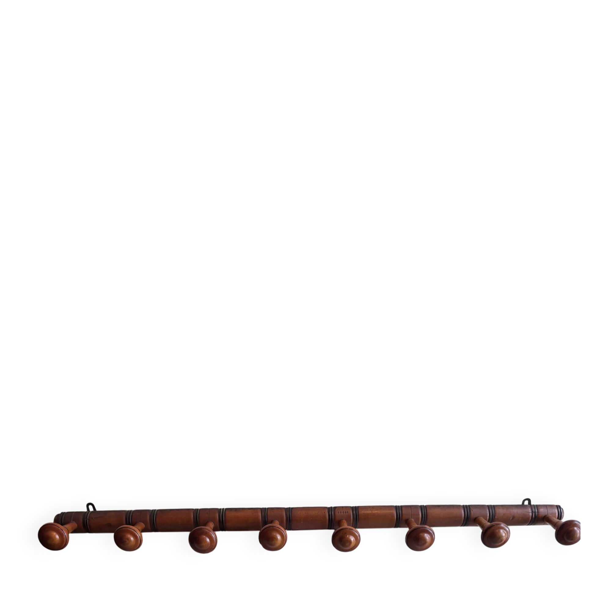 Wall-mounted coat rack with 8 turned wooden hooks in faux bamboo style.