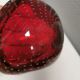 Small glass bowl in beautiful emerald red color with inlaid bubbles.