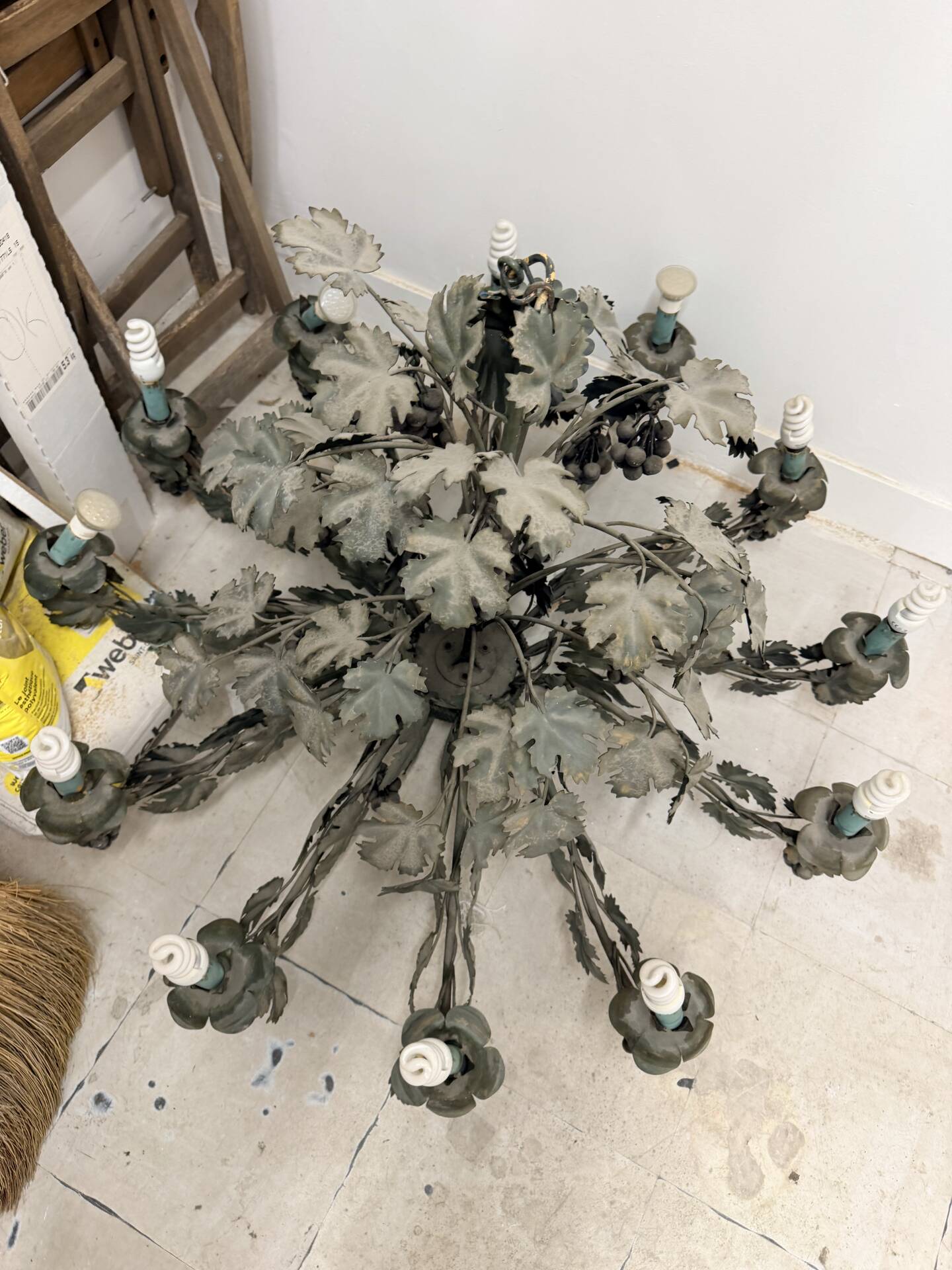 Old-fashioned country-style chandelier with virgin vine and bunch of grapes.