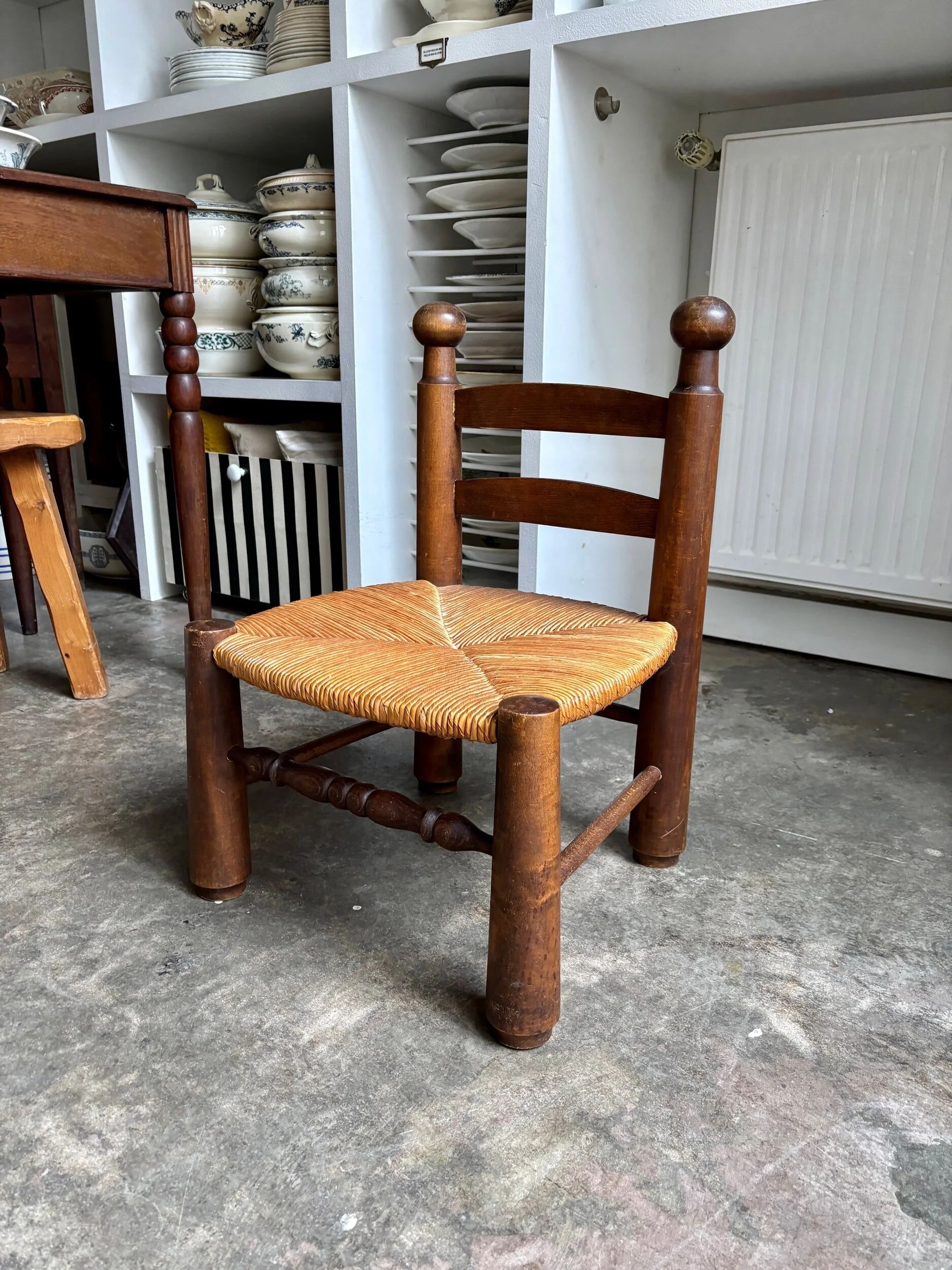 Brutalist low chair in dark wood and straw no. 1