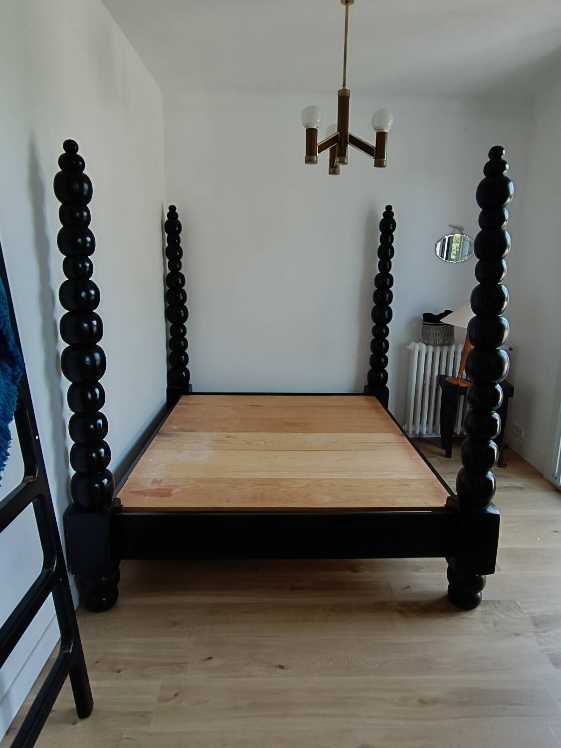 Black, solid wood four-poster bed, made by a craftsman in Mexico