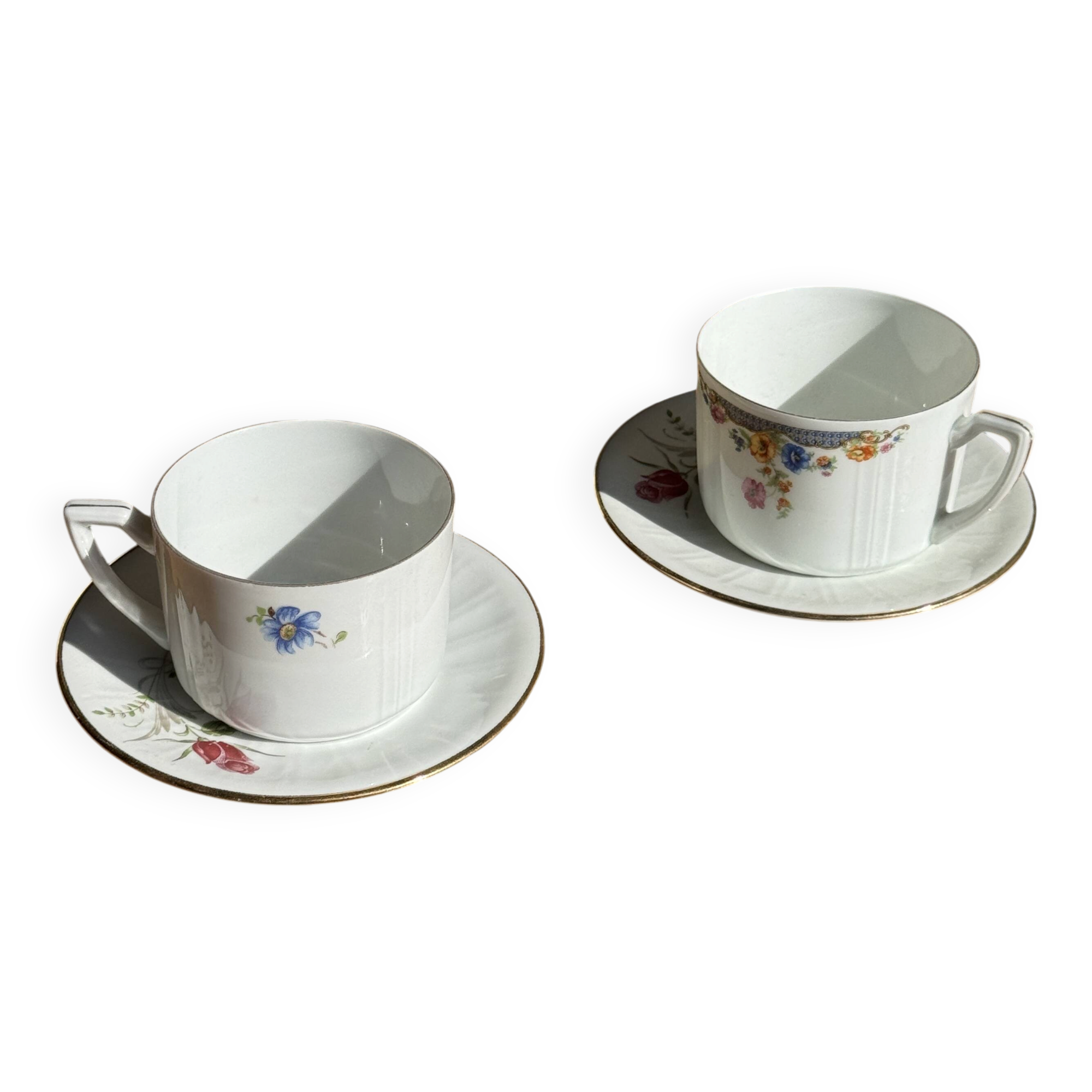 Pair of white porcelain cups from ADP France with a floral pattern and their s