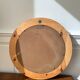 Round mirror in raw wood