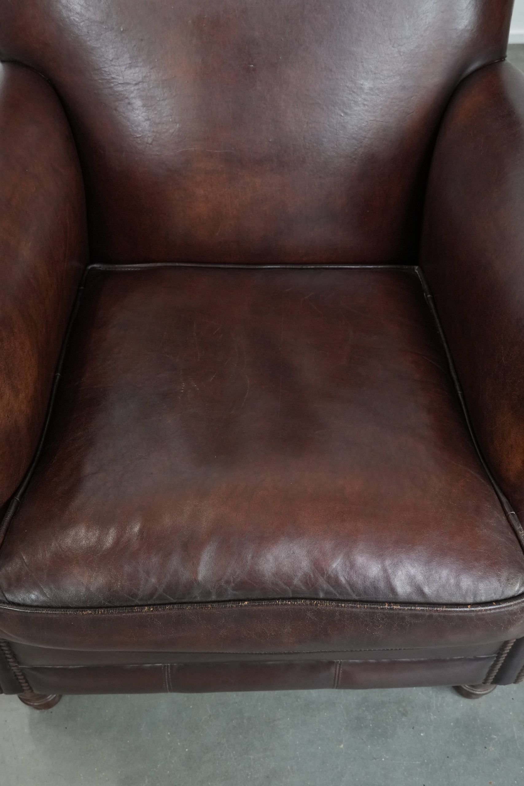 Sheepskin armchair with a classic finish and decorative studs.