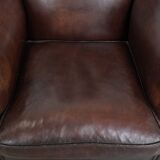Sheepskin armchair with a classic finish and decorative studs.