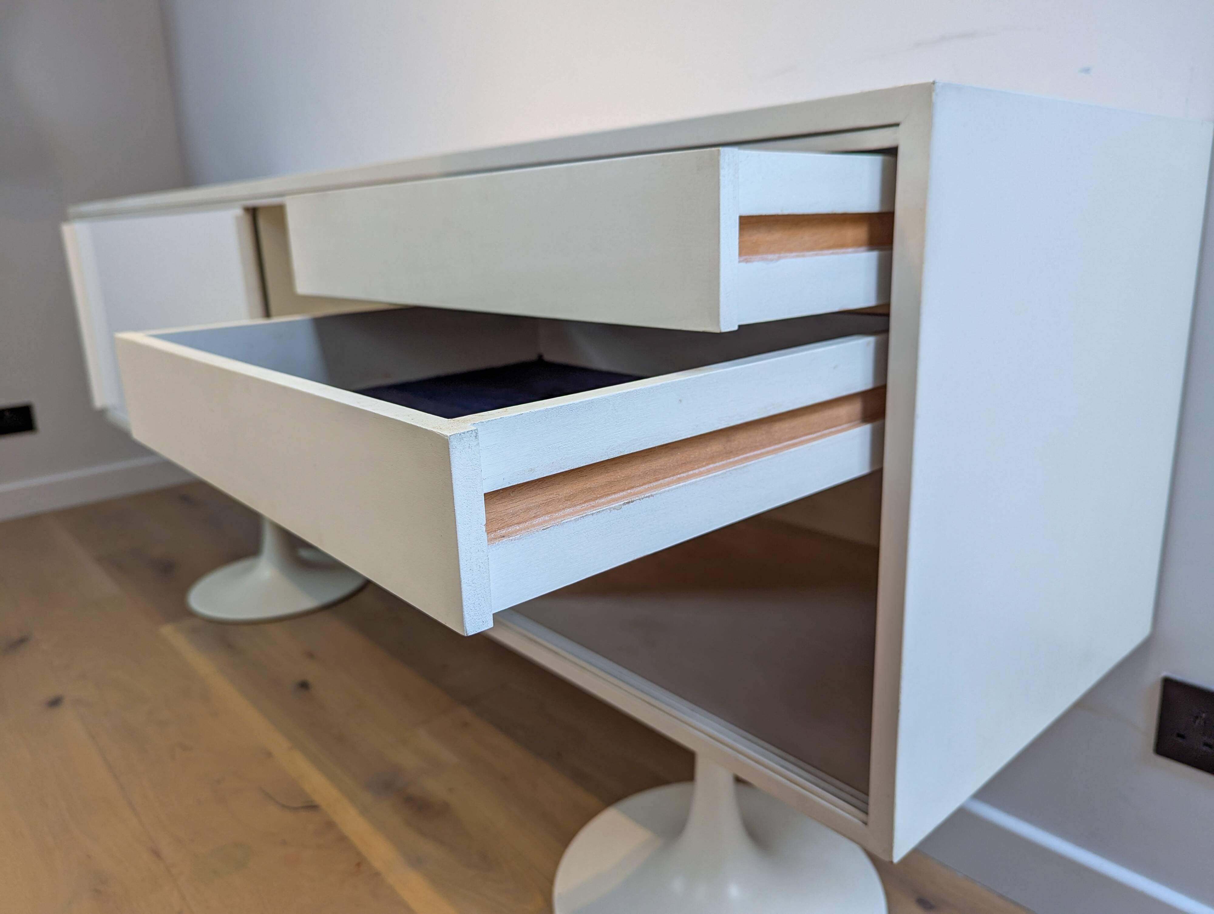 A vintage mid century space age sideboard with white sliding doors