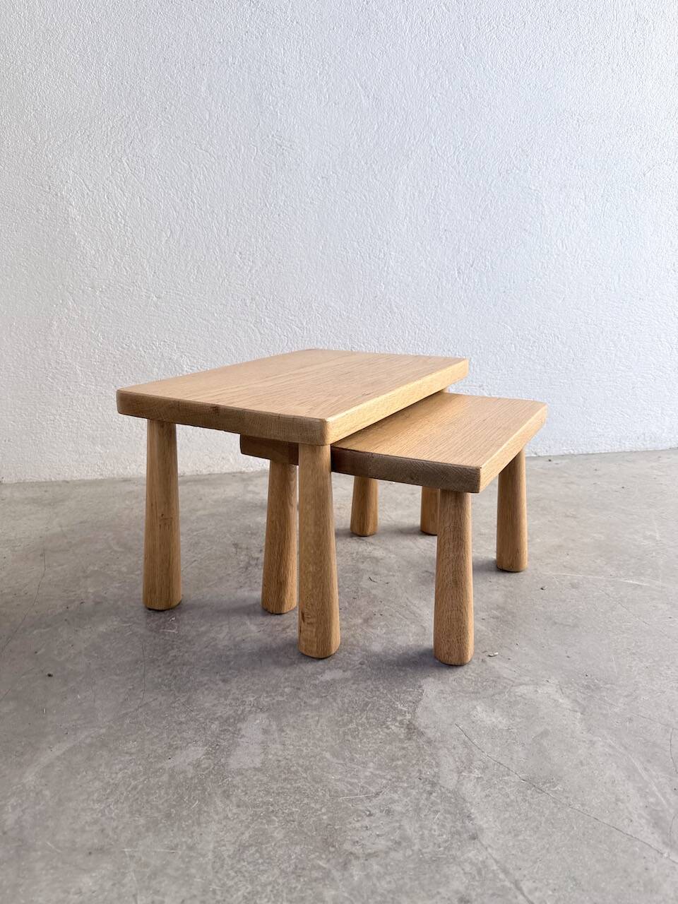 Two stools or small nesting tables in light oak.