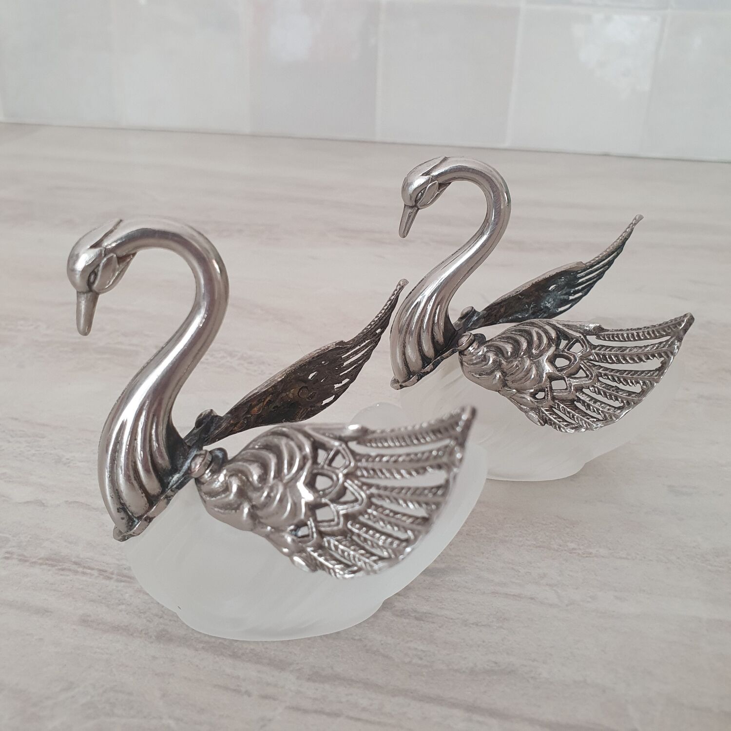 Two frosted glass swan salt cellars with silver plating.