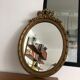 Old oval mirror with a pediment