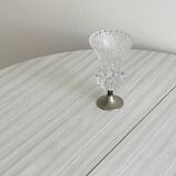 Small vase on a metal stand with thick glass.