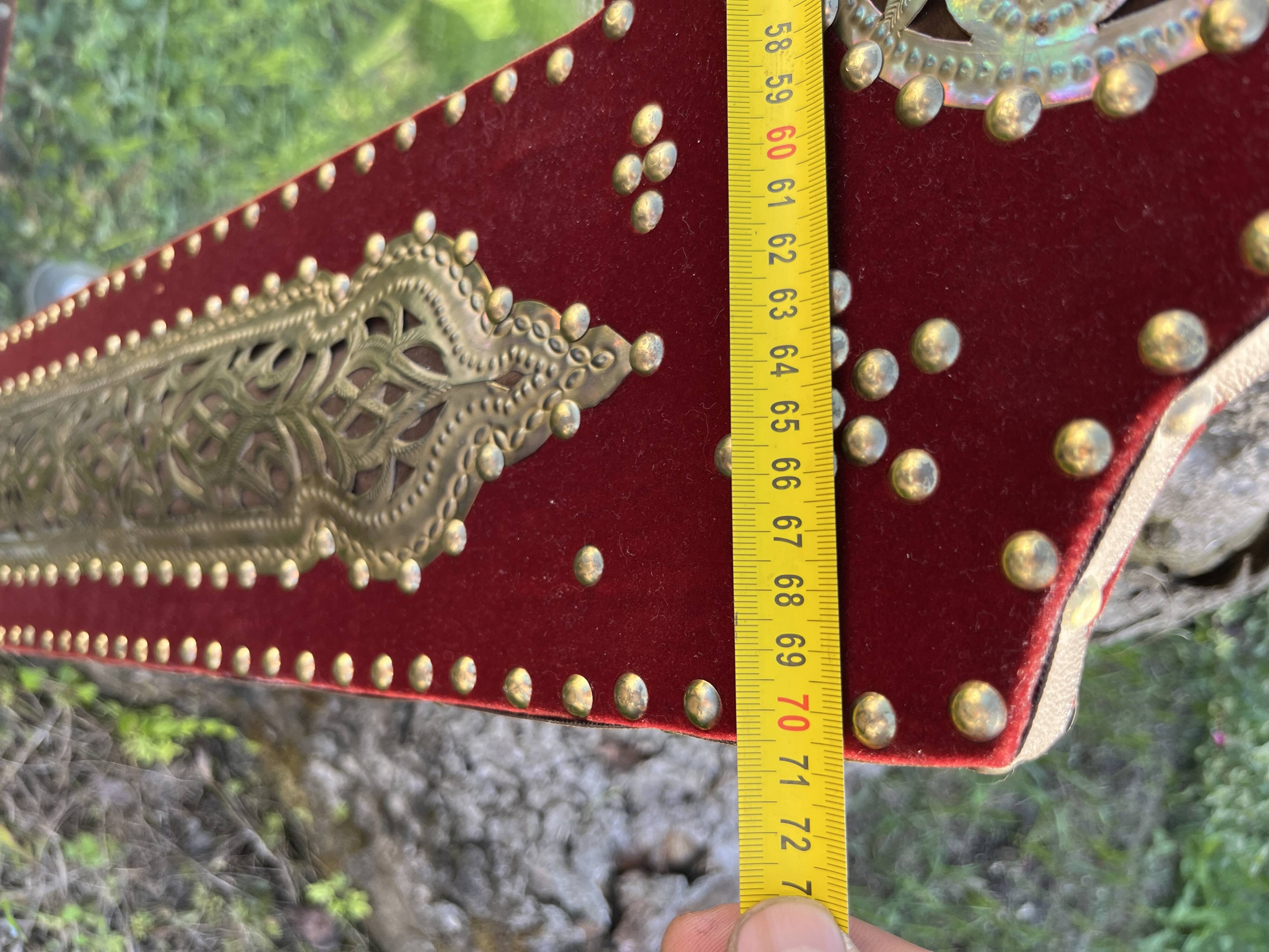 Large oriental mirror with embossed brass decoration on a red velvet background