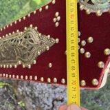 Large oriental mirror with embossed brass decoration on a red velvet background