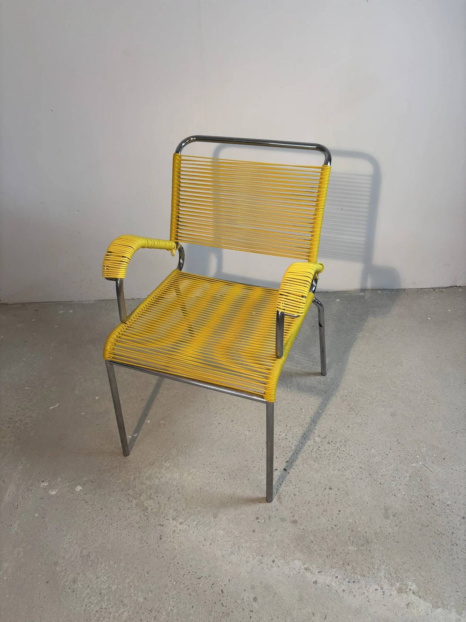 Fauteuil scoubidou jaune à structure tubulaire chromée