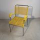 Yellow scoubidou armchair with a chrome tubular frame.