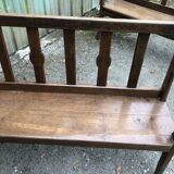 Duo of old solid oak benches with backs and armrests.
