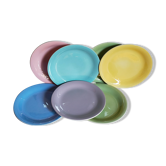 Seven pastel-colored plates mixed with vintage earthenware