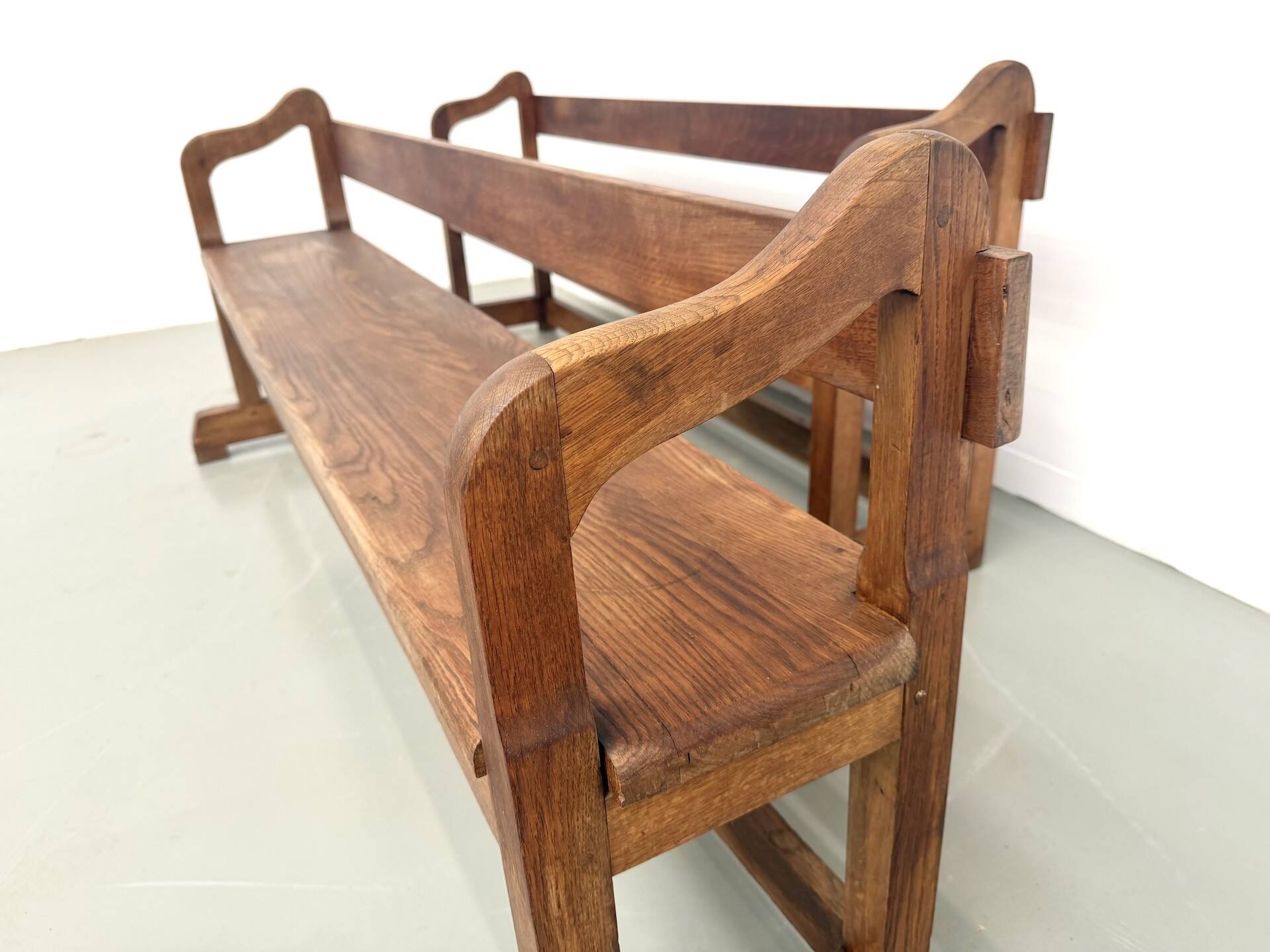 Pair of communal benches in solid oak, 1950s.
