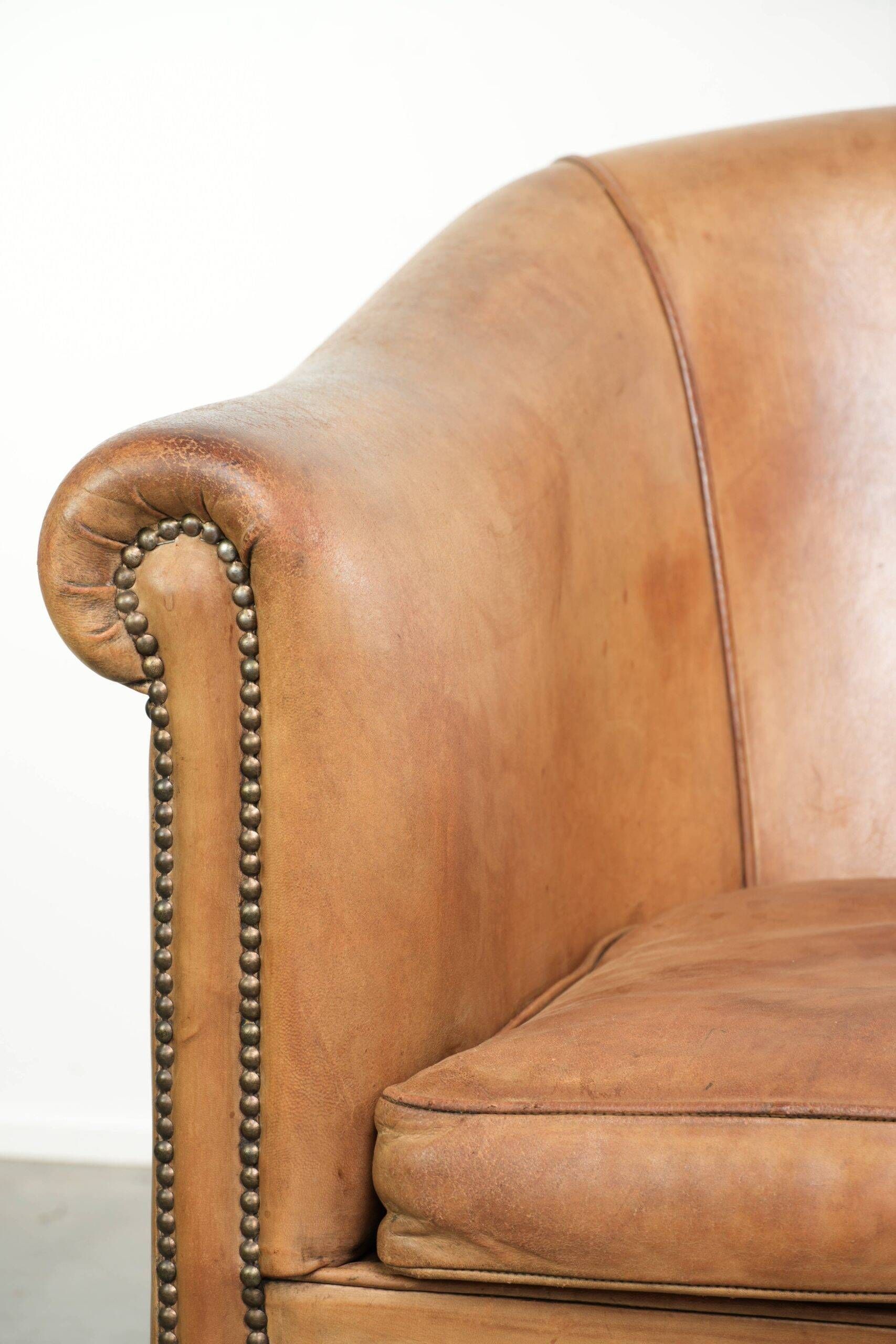 Fauteuil club en peau de mouton confortable de couleur cognac.