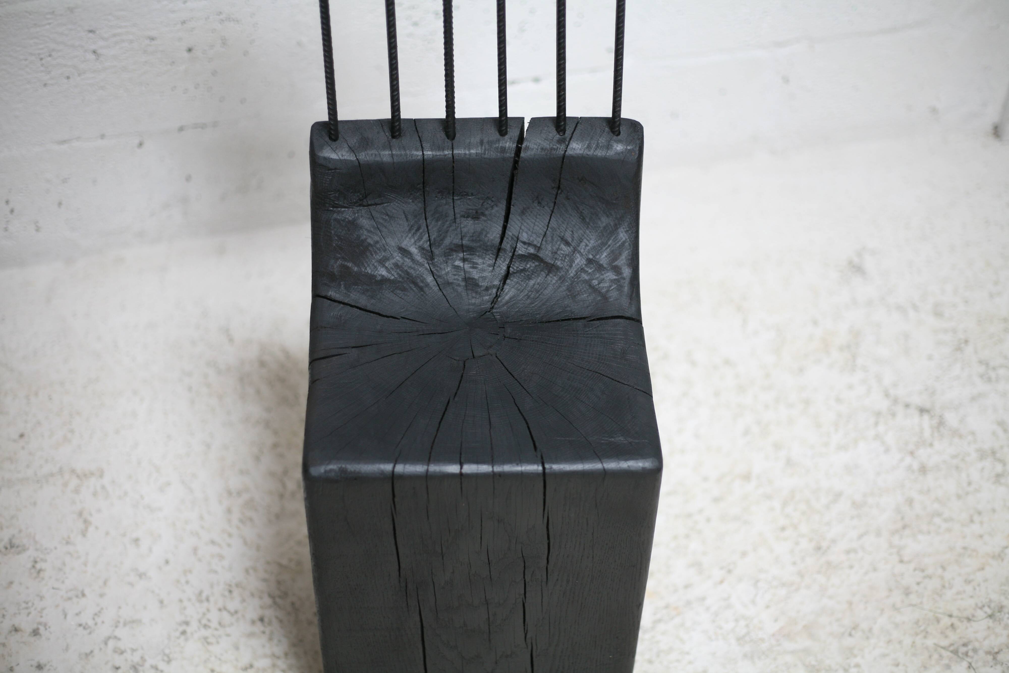 Brutalist chair, black-stained raw wood, steel. Work from the 1970s