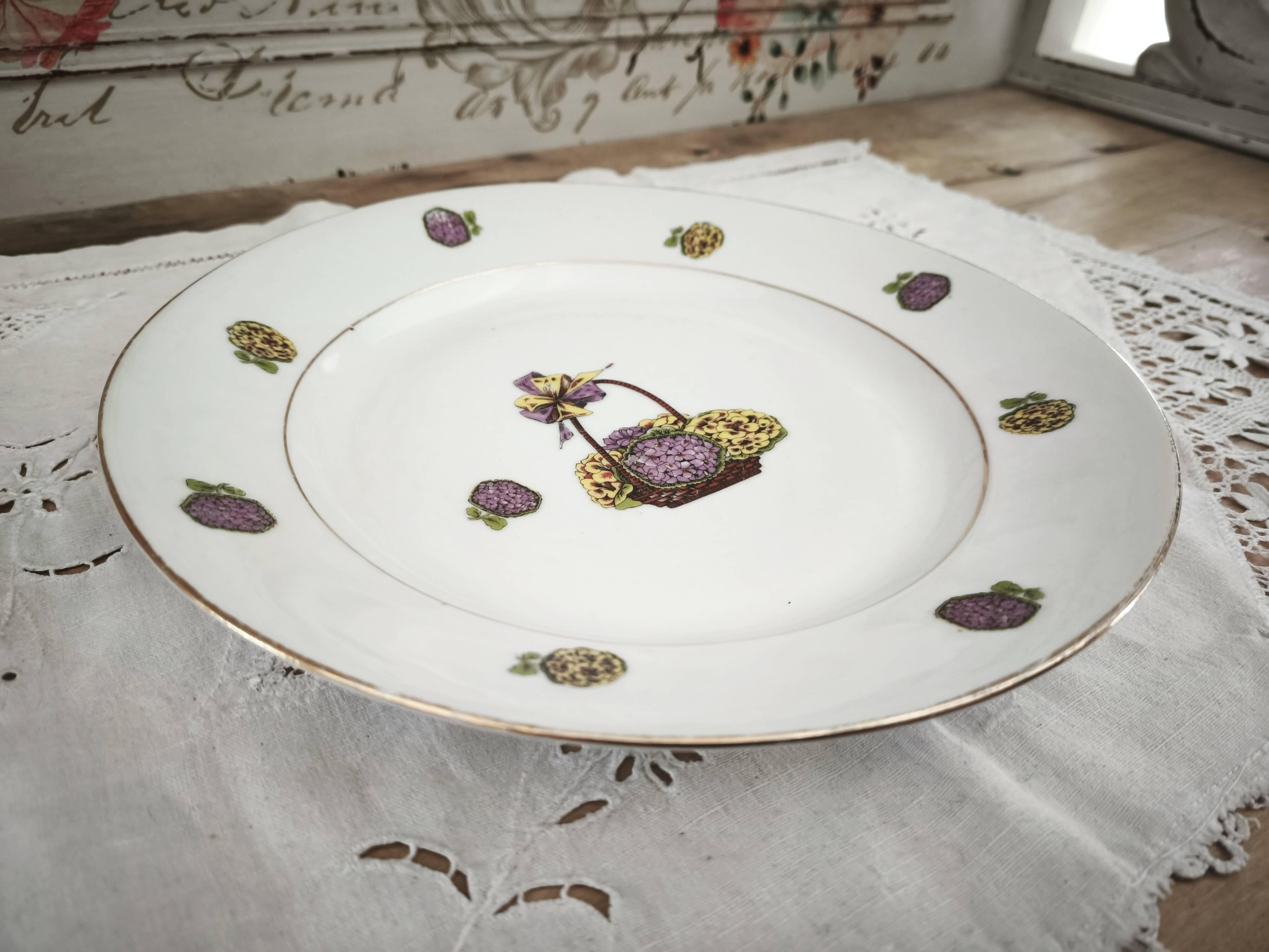 Round porcelain plate from Limoges with a hydrangea basket design.