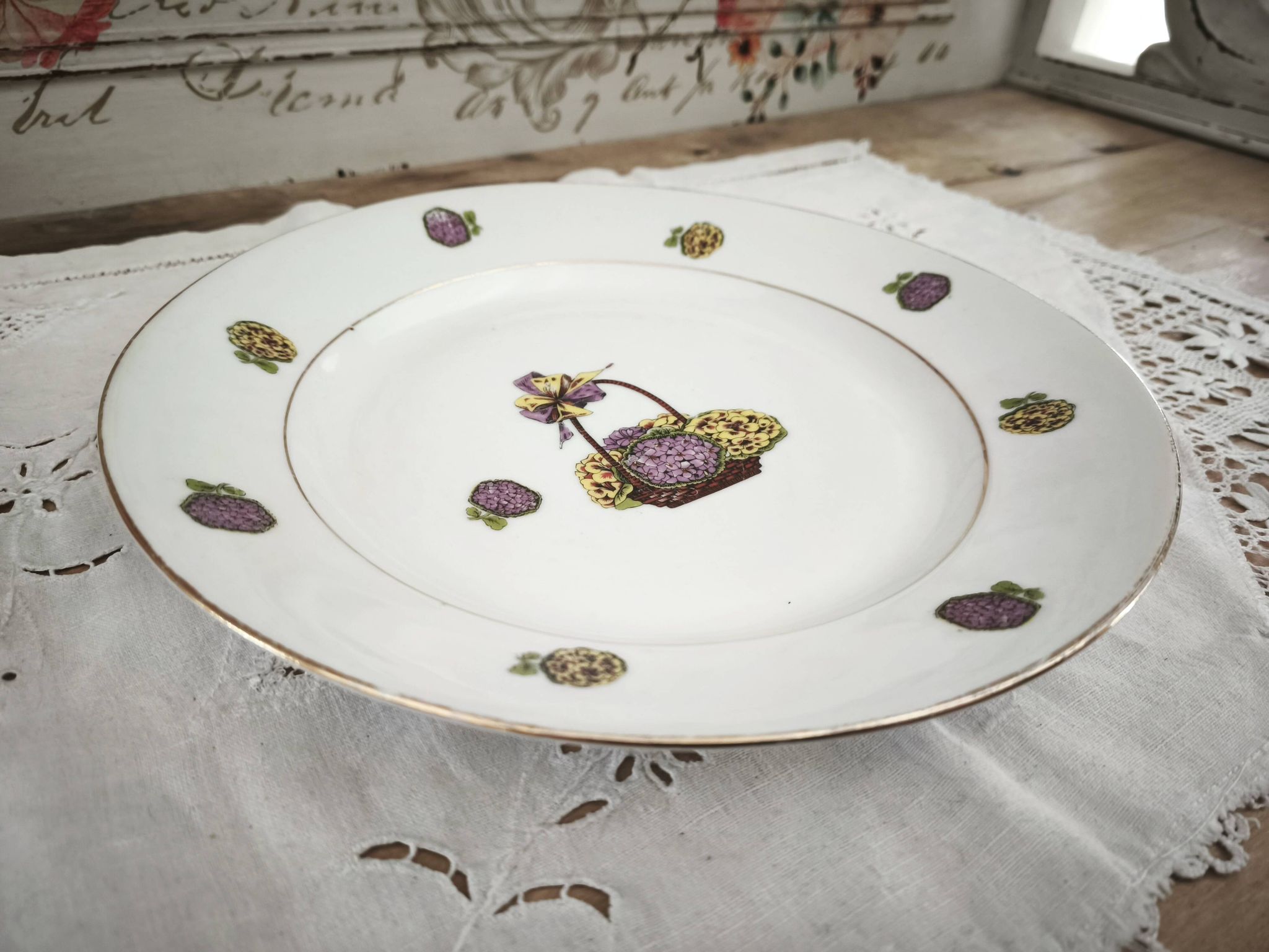 Round porcelain plate from Limoges with a hydrangea basket design.