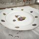 Round porcelain plate from Limoges with a hydrangea basket design.