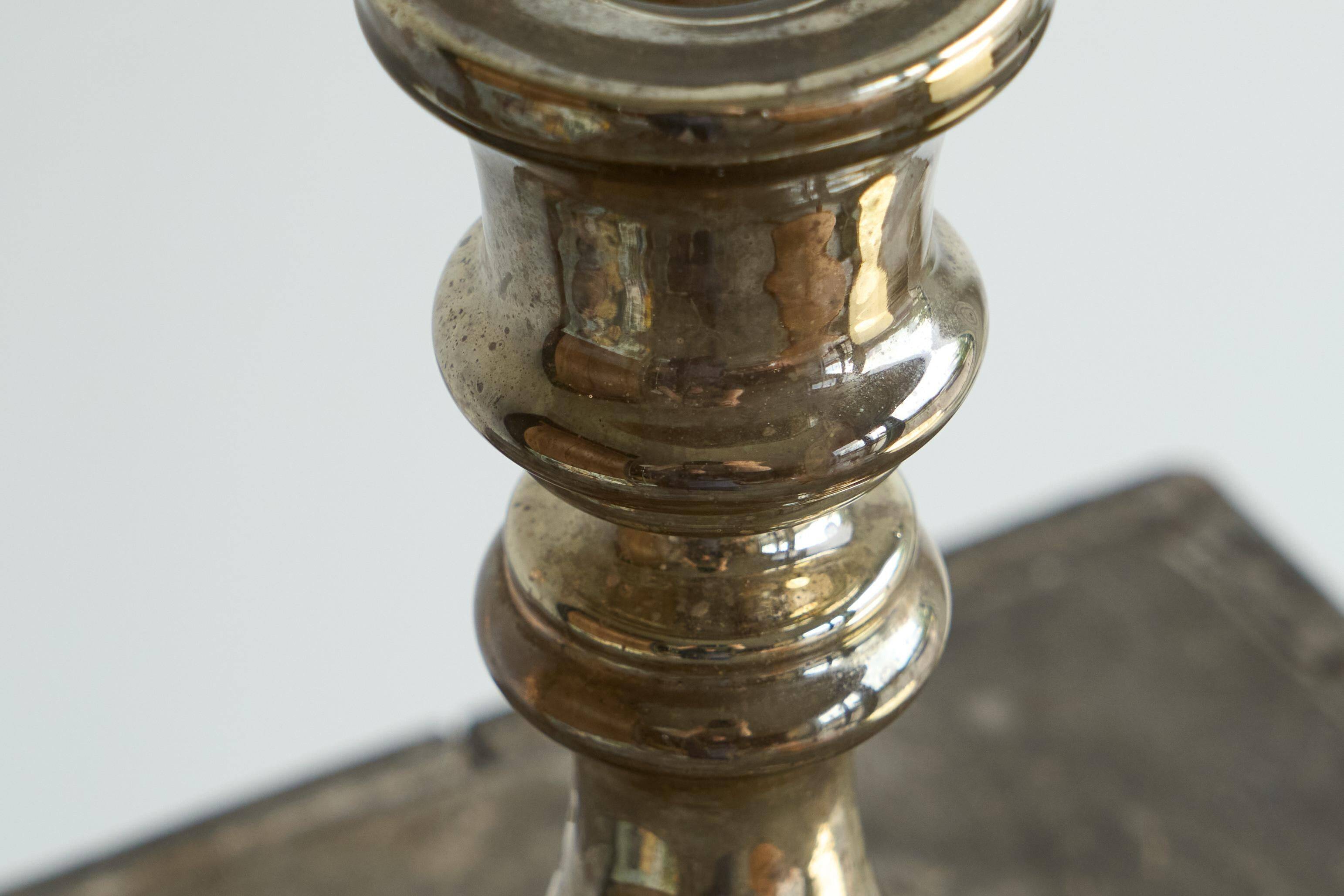 Antique mercury glass candlestick with a patina and silver finish.