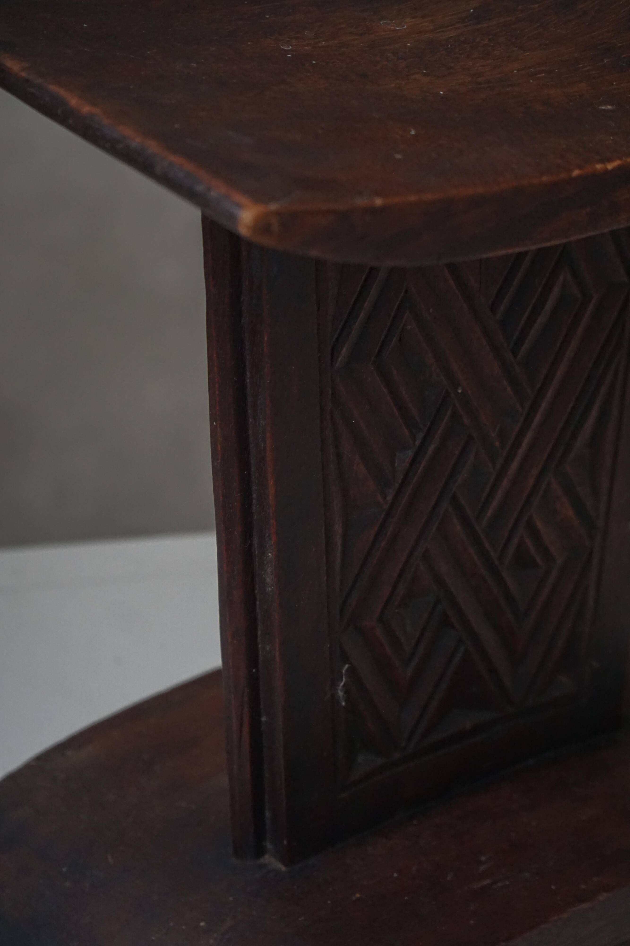 Sculptural African stool in hardwood, curved seat and architectural base, 1970s.