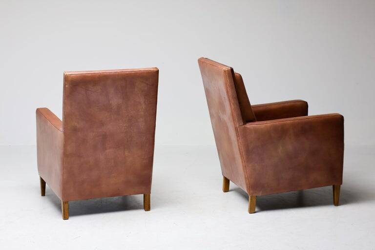 Pair of Art Deco armchairs in brown leather and teak, Netherlands, 1970s.