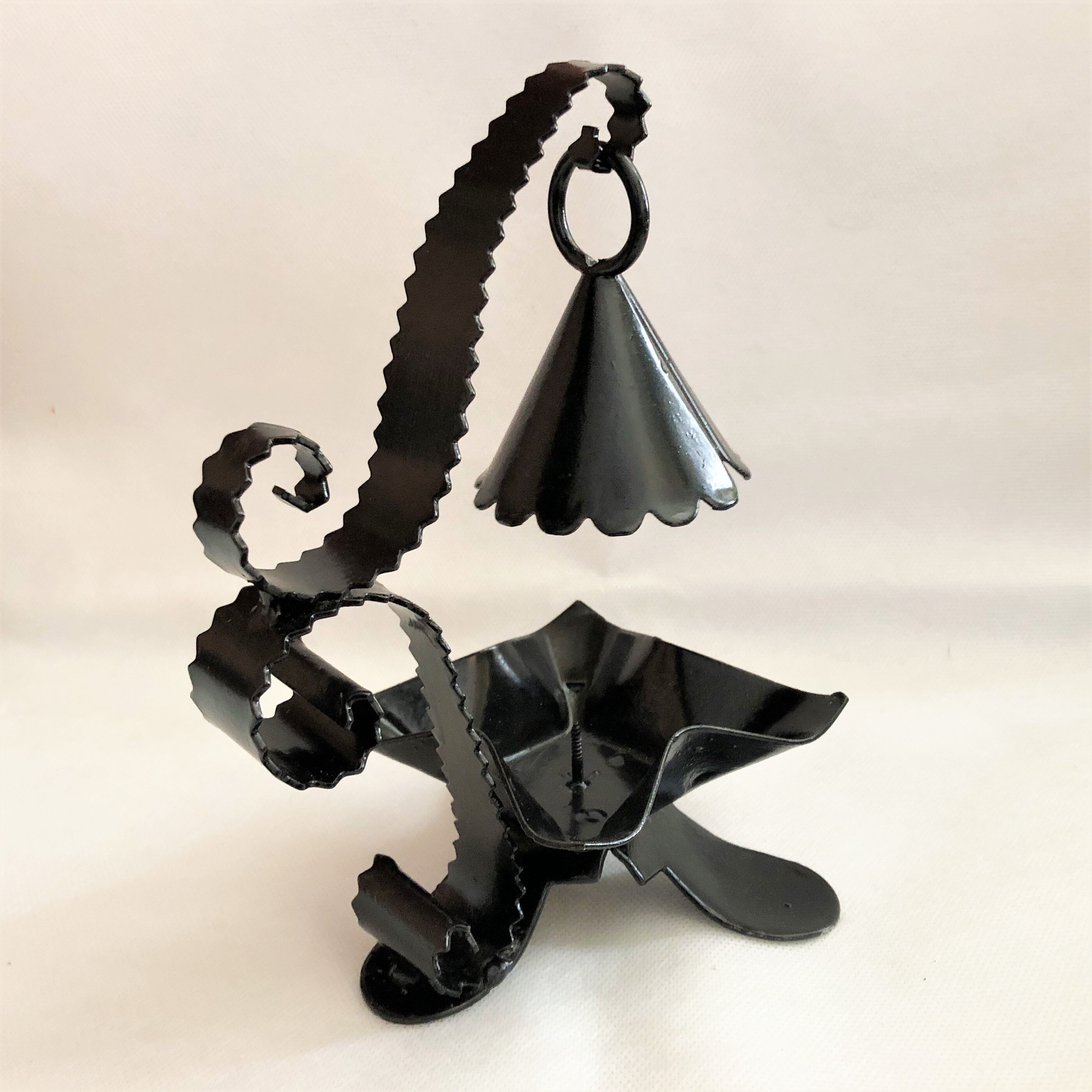 Handcrafted black wrought iron candle holder with its vintage extinguisher