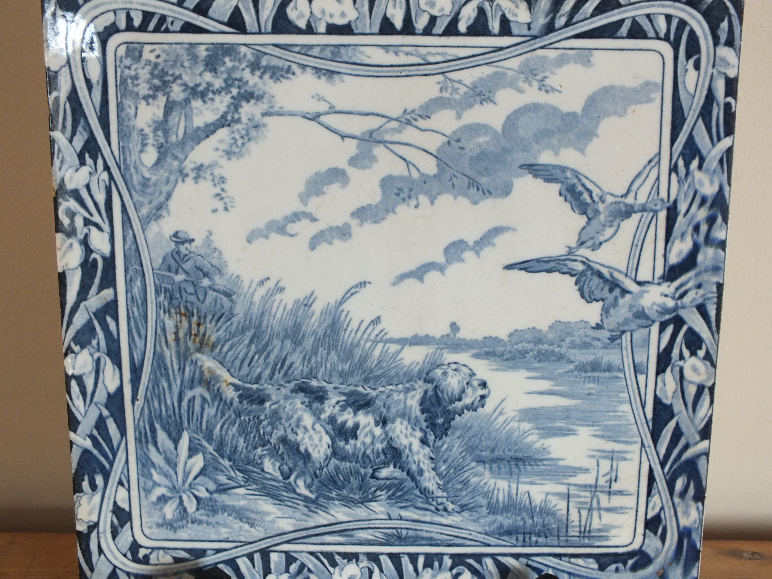 Old tile in Gien earthenware decoration hunting dog