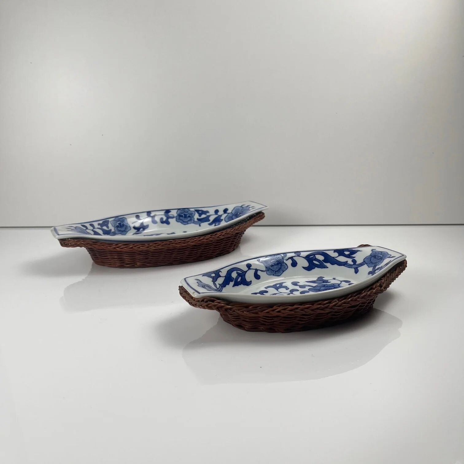 Set of 6 ceramic presentation plates in white and blue, floral pattern with woven wicker frame, 1970s/80s.