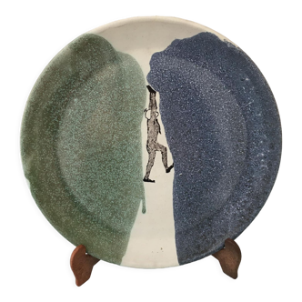 Assiette en céramique vernissée représentation homme entre deux terres signature inconnue
