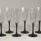Set of 6 Octime champagne flutes in glass with black stem.