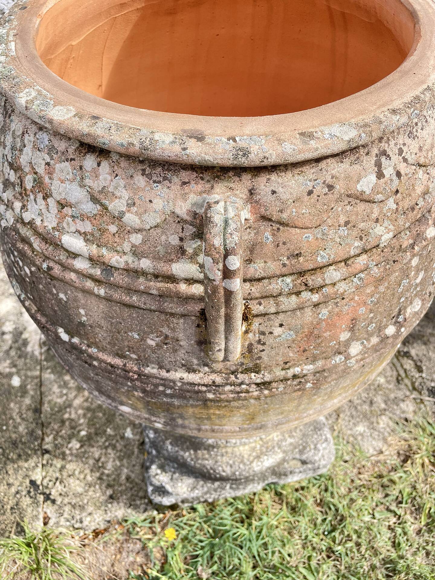 Large Cretan jar in terracotta with three handles on a stone base.