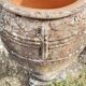 Large Cretan jar in terracotta with three handles on a stone base.