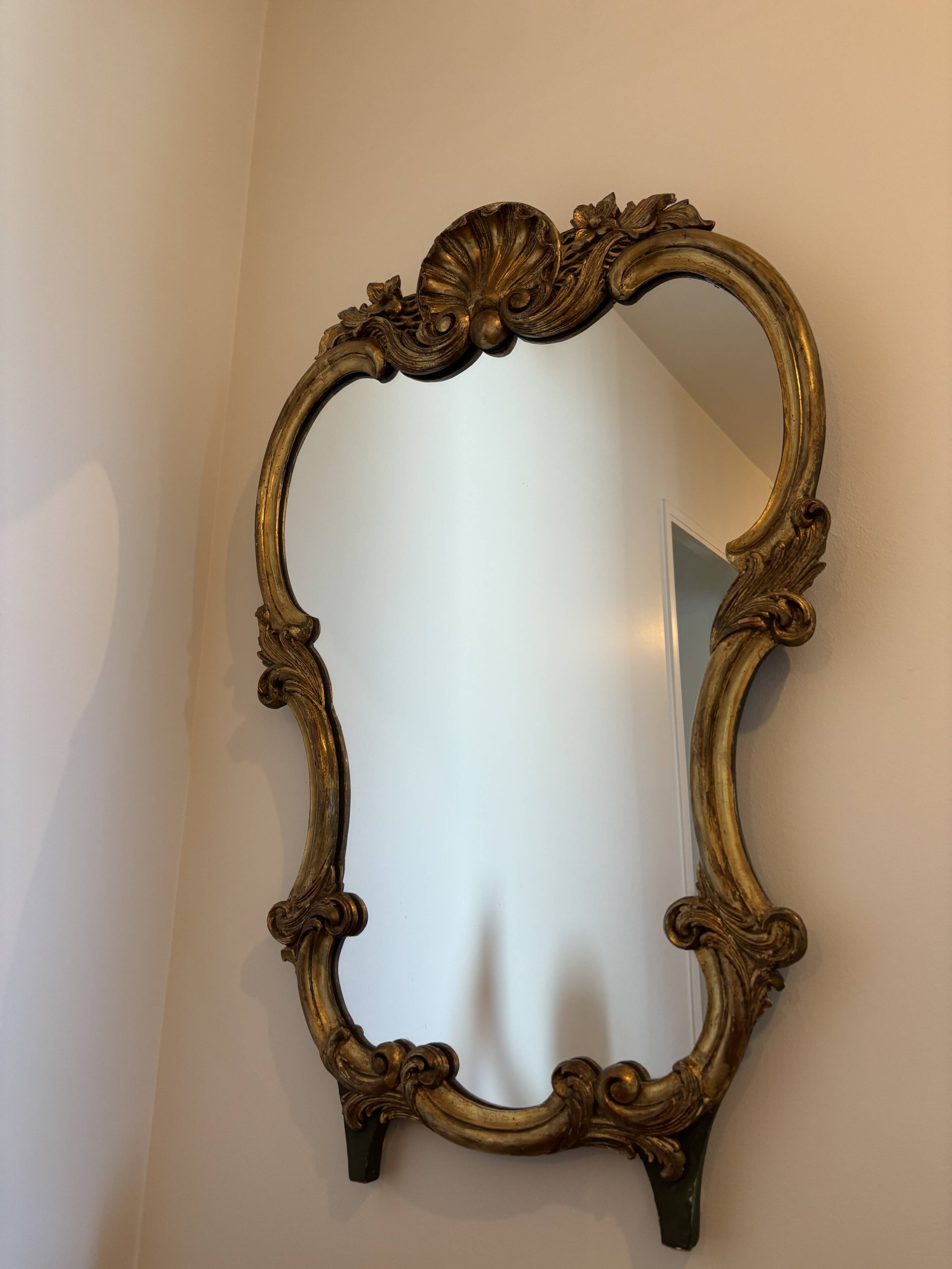 Large wall mirror with a gilded brass frame in Louis XV style.