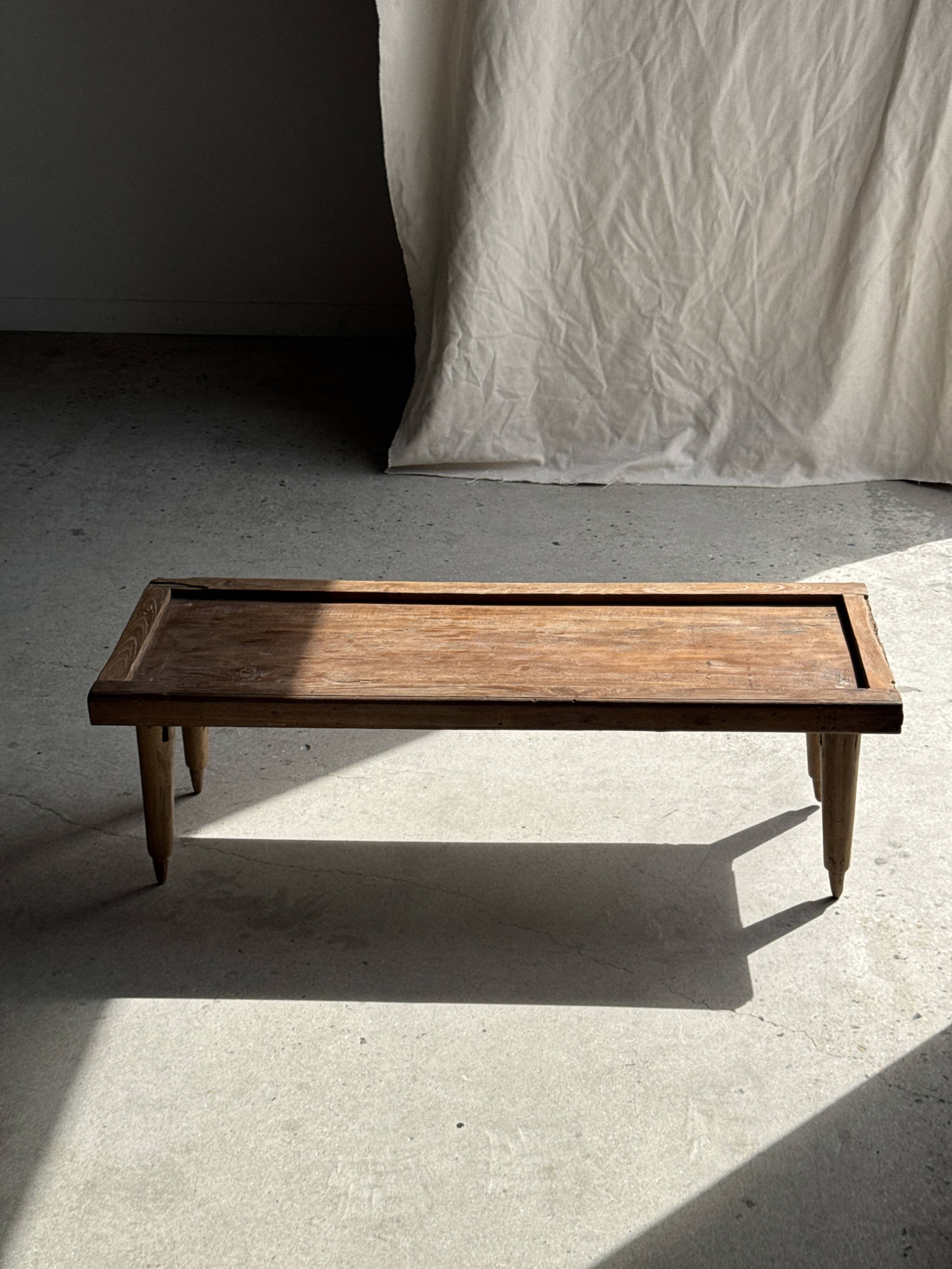Brown Indonesian teak coffee table, with a border and cylindrical legs H40 L103.