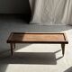 Brown Indonesian teak coffee table, with a border and cylindrical legs H40 L103.