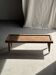 Brown Indonesian teak coffee table, with a border and cylindrical legs H40 L103.