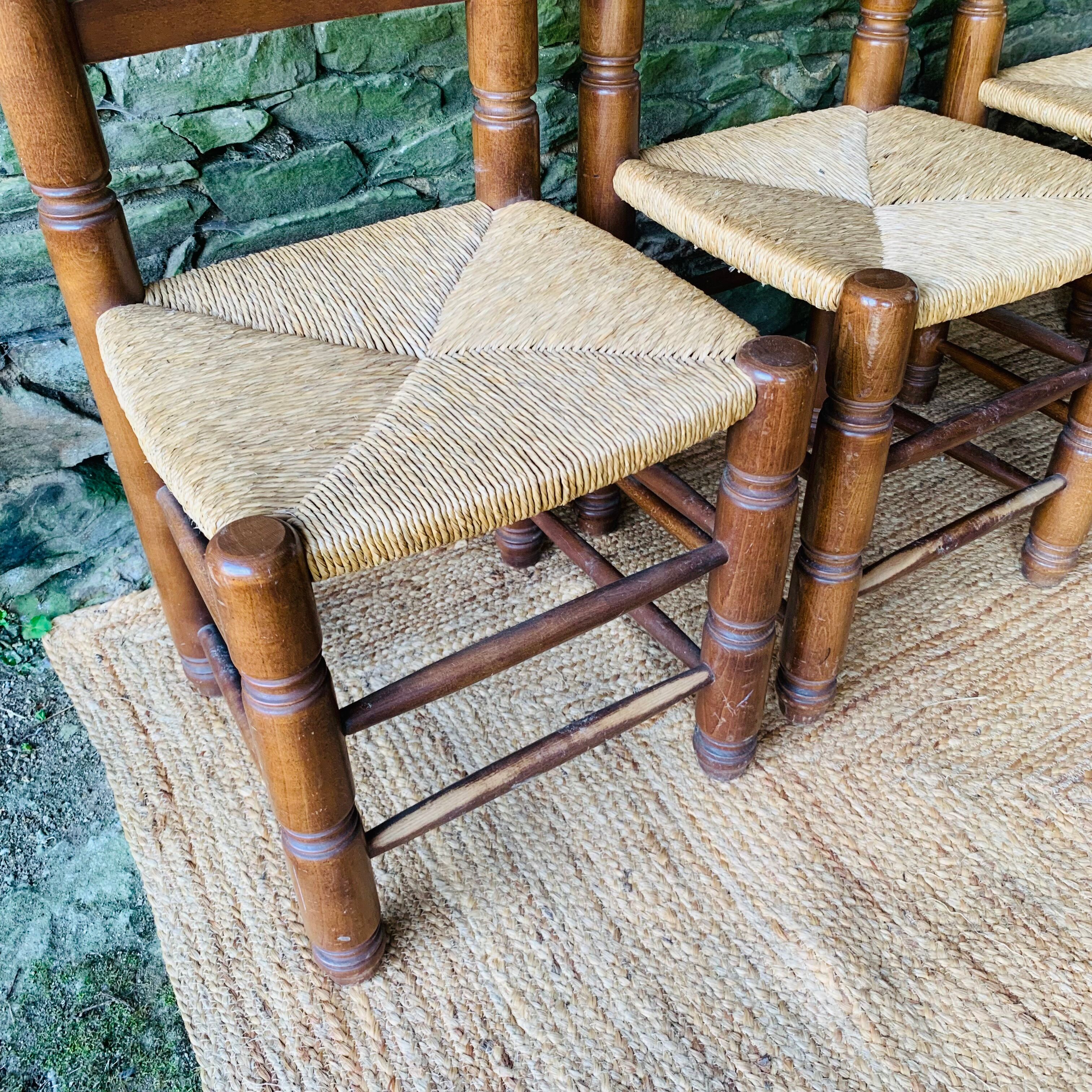 Set of 4 solid wood chairs with straw seats.