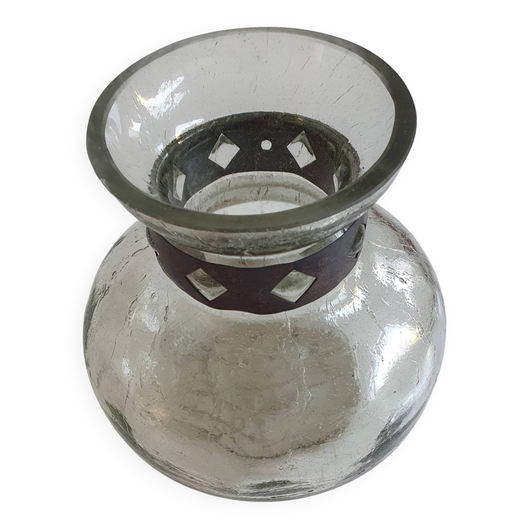 Cracked glass vase encircled with wrought iron.