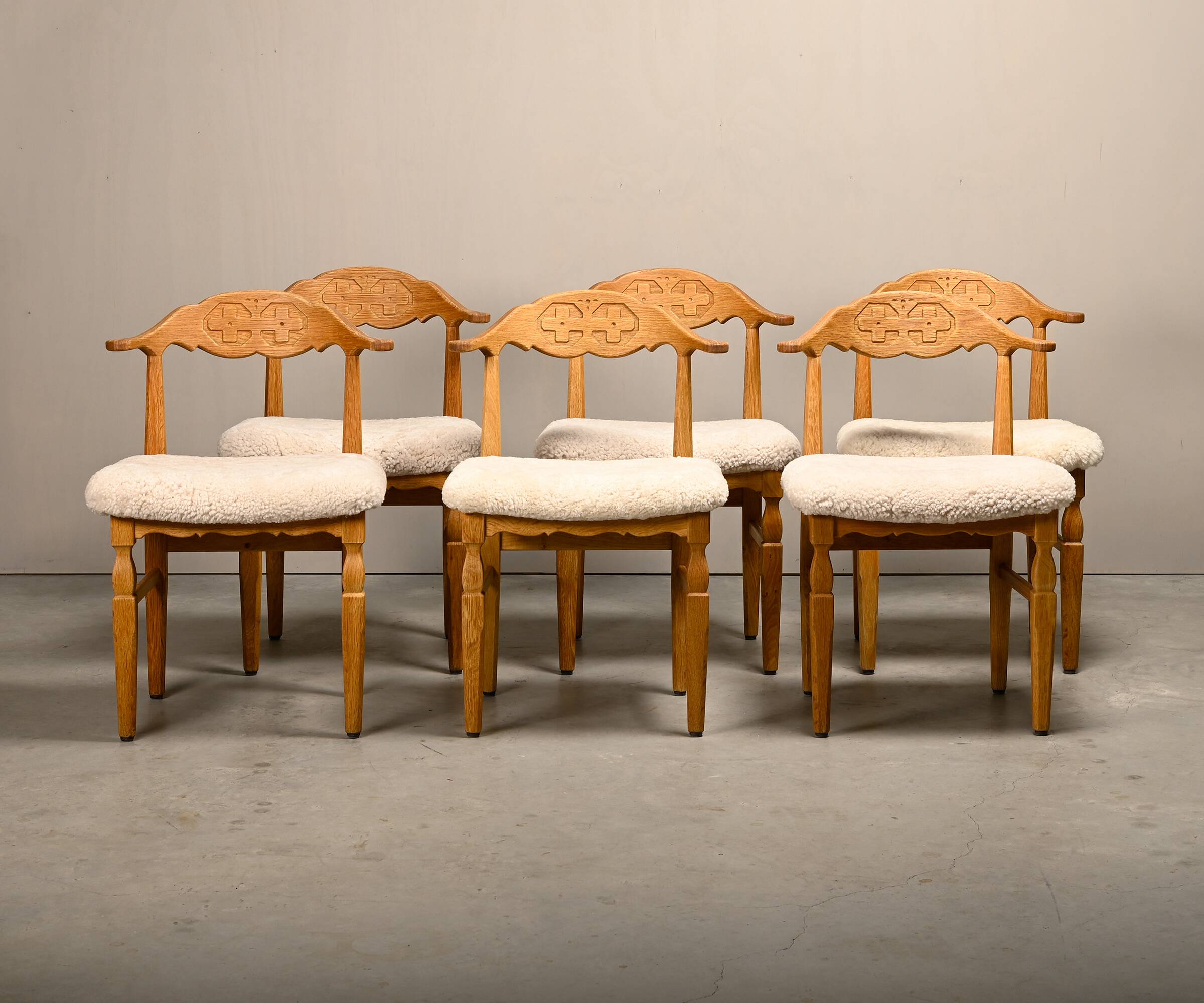 Henning Kjærnulf dining chairs set in Oak and Sheepskin, Denmark, 1960s