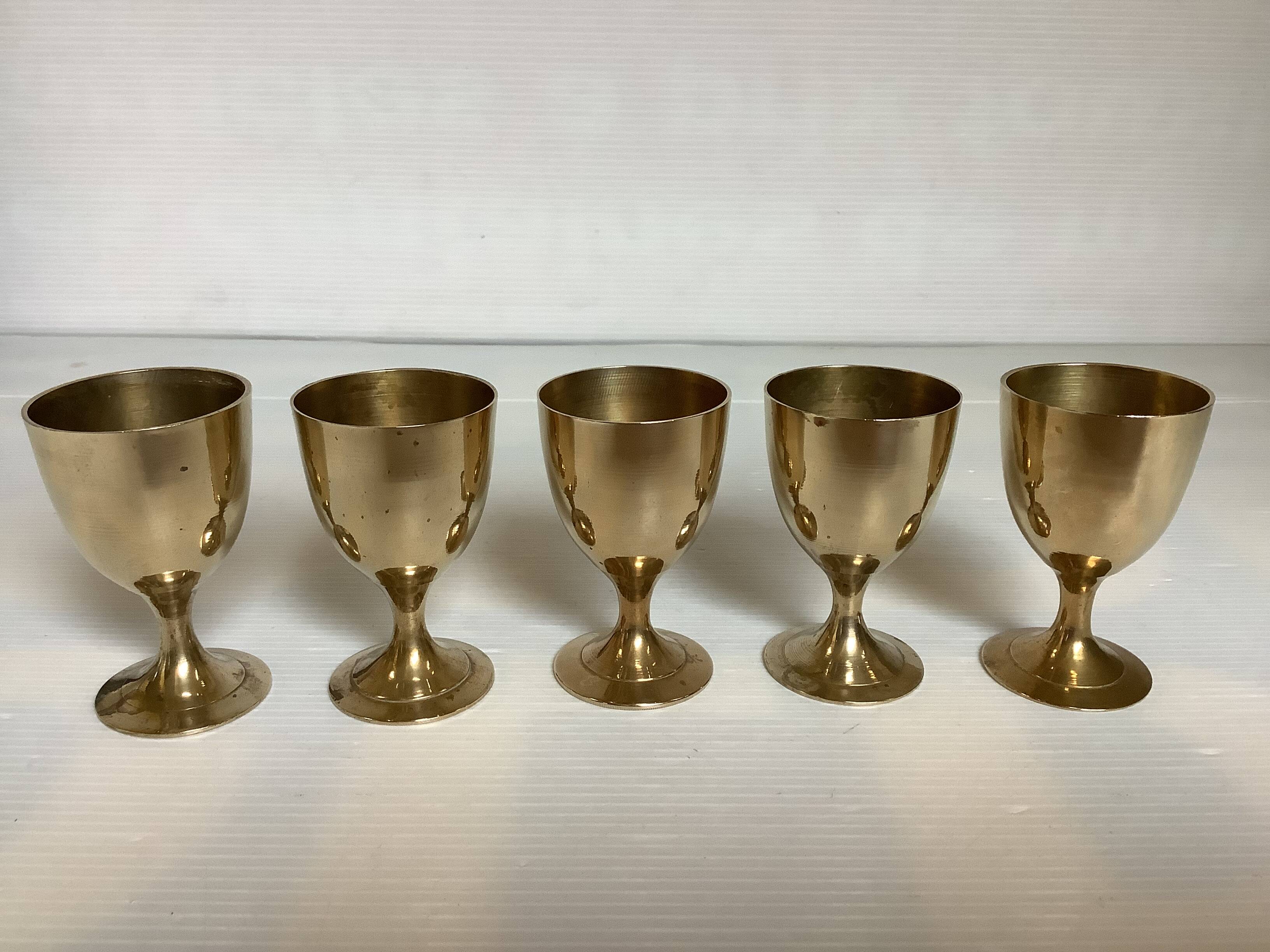 Five brass egg cups